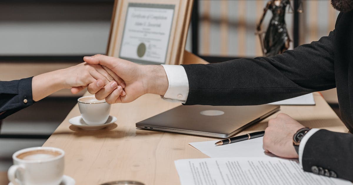 Business professionals shaking hands over a contract, representing competitive dynamics in the money transfer industry